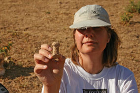 Archaeologist Lisa Cooper holds a baked clay animal figurine - photo by Bernard Lachance