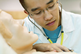 Third-year Nursing student, Kelvin Bei, checks vital signs on a computerized patient simulator - photo by Martin Dee